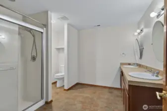 3/4 Bath of the second suite with tile floors and dual vanity.