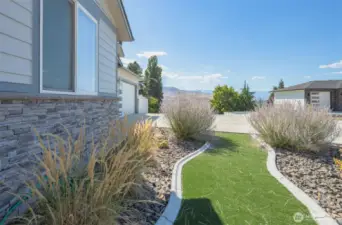 Landscaped front yard featuring decorative rock and lush turf for low-maintenance living and enhanced curb appeal.