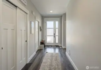 Down the hall, two additional bedrooms are located to the right, separate from the primary suite, while the laundry room and garage are conveniently to the left.