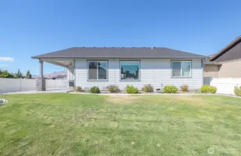 Fully fenced, flat backyard with ample grass space and simple landscaping for minimal upkeep