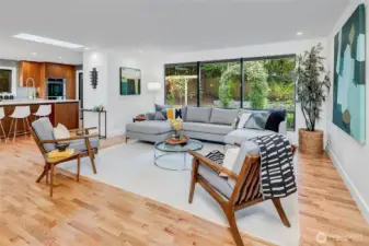 The beautiful white oak floors were refinished throughout the home (Swedish finish) in September 2025. The open living area flows effortlessly into the kitchen and dining area. Abundant natural light with new energy-efficient picture windows and remote-controlled skylights. (It is a beautiful PNW day, and the skylights are open- it starts to rain out of nowhere and you are not home- no worries... the skylights will close automatically if they sense rain!) The open floor plan flows into a stunning chef’s kitchen with sleek high-end appliances, expansive counters, and custom cabinetry—designed for both serious cooking and stylish entertaining.