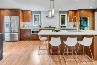 The kitchen is the heart of the home, featuring a 5-burner gas cooktop, double ovens, drawer microwave, and custom cabinetry from