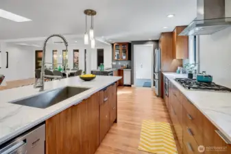 A view from the kitchen looking towards the laundry room and garage access. Park in the garage and unload your groceries easily. A pocket door separates this space while entertaining guests.