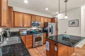 Chef’s kitchen with granite counters, stainless steel appliances, and ample cabinetry