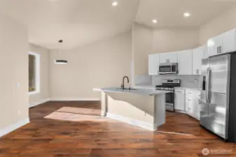 The updated kitchen features brand new cabinets, quartz countertops, new flooring, and GE stainless steel appliances including a refrigerator, gas range, microwave hood, and dishwasher.