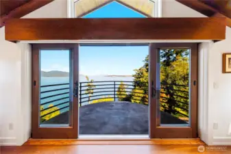 From the private executive office, a captain’s style balcony with vaulted wood ceiling and beams extends outward to sweeping island and mountain views.  This is on the third floor, accessible by elevator.  It has a private powder room and warming fireplace.