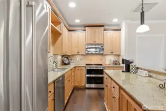 The kitchen is thoughtfully appointed with slab granite countertops, stainless steel appliances, New Double oven, a wine fridge, and under-mount lighting.