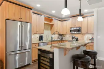 The kitchen is thoughtfully appointed with slab granite countertops, stainless steel appliances, New Double oven, a wine fridge, and under-mount lighting.