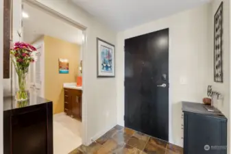 The entry area has plenty of room for storage. The bathroom door is shown to the left.