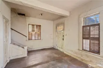 The front entry of the home, though not currently accessible, leads into a small foyer and to the living room.