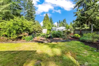 The spacious back yard is fully fenced and full of flowers and grassy space.