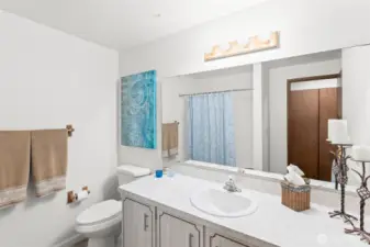 Newly surfaced countertops create a bright and clean guest bath.