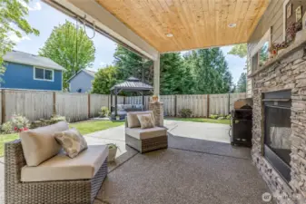 Covered patio with fireplace, sun/privacy shades and ceiling fan