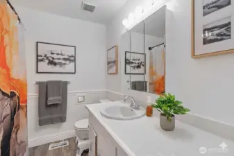 Full bath with large vanity has a mirrored, three paneled medicine cabinet perfect for personal storage.