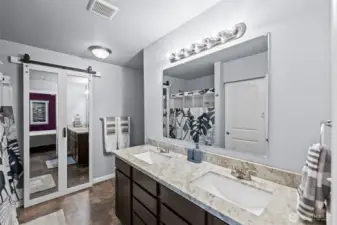 main bath with double sinks mirrored door opens to huge walk in closet