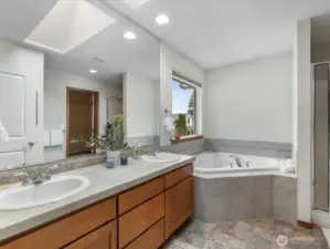 Bright, skylit primary bath with dual sinks—designed for both comfort and everyday ease.