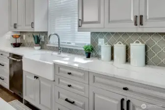 Updated kitchen includes new quartz counters and tile backsplash, newer appliances