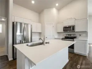 The kitchen is well-lit with ample overhead lighting and natural light from the many nearby windows.