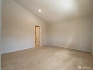 The private primary suite is spacious and features vaulted ceilings.