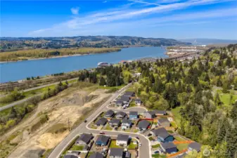 This view shows the home's close proximity to the Columbia River and waterfront activities. A small river-cruise ship can be seen at the dock along the east side of the river.