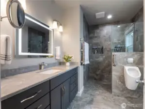 Tiled roll in shower in the primary bathroom, lighted mirror gives this bathroom a luxurious feel. The Bathroom floor is heated for ultimate comfort.