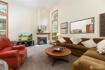 Living room with gas fireplace and soaring open ceilings.