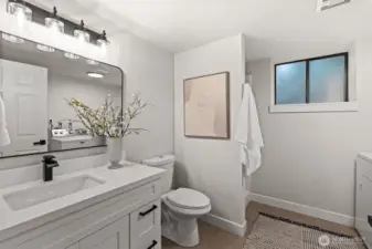 Modern, spacious three-quarter bathroom with washer and dryer.