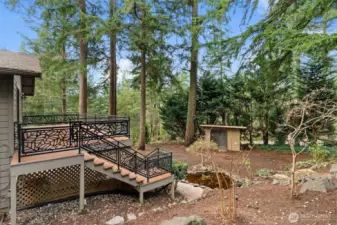 Attractive stair railing with bonus storage shed and a quaint pond in the backyard.