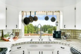 Picturesque views right from your kitchen sink! Freshly painted cabinets and updated hardware breathe new life into timeless details, creating a space that’s equal parts classic and refreshed.