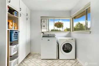 The convenient laundry room offers generous storage or a bonus pantry, and easy outdoor access to the right, which leads to the detached garage - making grocery runs a breeze.