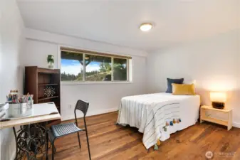 Spacious and sun-drenched, this bedroom pairs durable luxury vinyl floors with a cedar-lined closet to create a retreat that’s as functional as it is inviting.