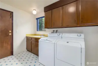 Oversized Utility Room  Maytag Washer and Dryer  Folding counter, utility sink  Cabinet storage  Upper and lower storage cabinets  Window to side yard  Door leading to garage