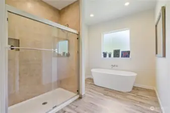 Large tiled shower with glass doors.