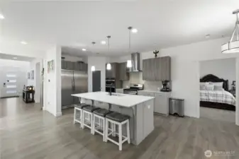 ~The gourmet kitchen is a chef’s dream—highlighted by custom cabinetry, quartz countertops, stainless steel appliances, a large island, and a walk-in pantry~