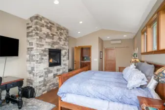 Primary Suite has an entry point to the spacious deck. a gas fireplace and fir trimmed windows that offer so much natural light.  Engineered cherry hardwood floors.