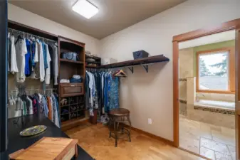 Primary Suite Walk in closet with built in shelving, soft cork flooring, and convenient access to the laundry room