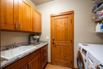 Laundry Room with cork flooring and entry point into primary suite walk in closet.