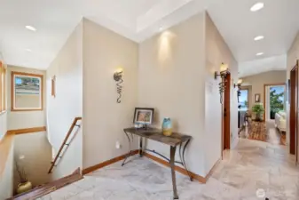 Welcoming entry with custom lighting, elegant tile floors, and a glimpse of bay views just beyond.