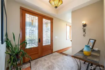 Welcoming entry with custom lighting, elegant tile floors, and a glimpse of bay views just beyond.