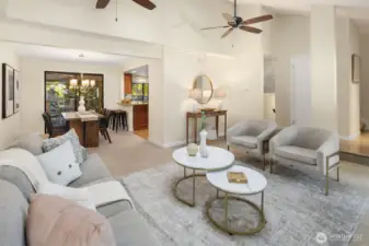 Living room with vaulted ceilings, gas fireplace, ceiling fans, and skylight
