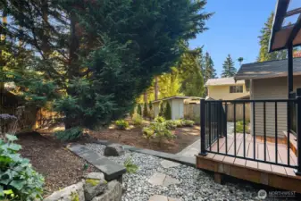 Landscaped backyard with paver walkway and storage shed.