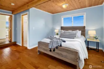 The primary bedroom is large and bright and features wood flooring, a cedar-lined closet, and an updated bathroom