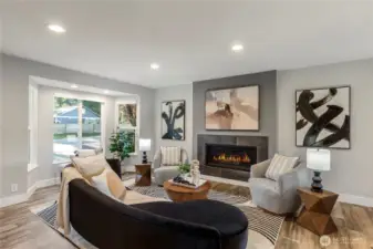 Bright and inviting living room featuring a cozy modern fireplace, and large windows that fill the space with natural light.