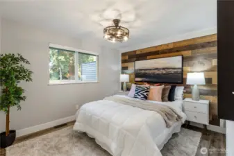 Spacious primary with rustic accent wall, and also includes built in shelving in the closet.