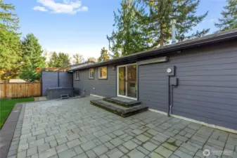 Expansive paved patio with easy access from the home—ideal for outdoor dining, entertaining, or relaxing in a private backyard setting.