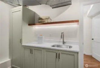 The laundry room has beautiful cabinetry and soaking sink.