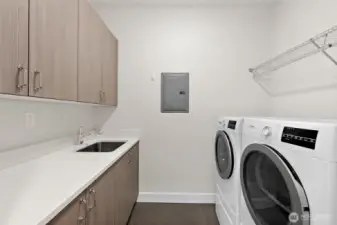 Laundry room with storage, laundry sink and ductless dryer.  Washer and dryer stay with the home.