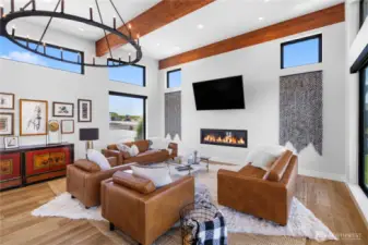 Living room. Features high ceilings, windows and wood beams throughout.