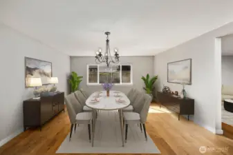 Virtually staged formal dining room with hardwood floors connected to the open concept living and kitchen area.