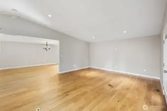 Open living and dining space with hardwood floors and recessed lighting, offering an easy flow into the adjoining living areas.